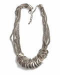 Flätat halsband med bred front av silvertonade skivor