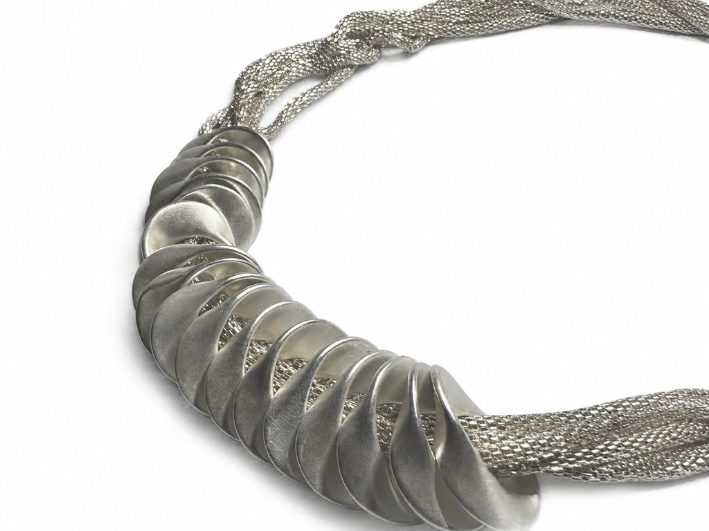 Flätat halsband med bred front av silvertonade skivor